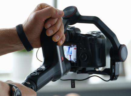 videographer-holds-stabilizer-with-camera-hands-closeup 1